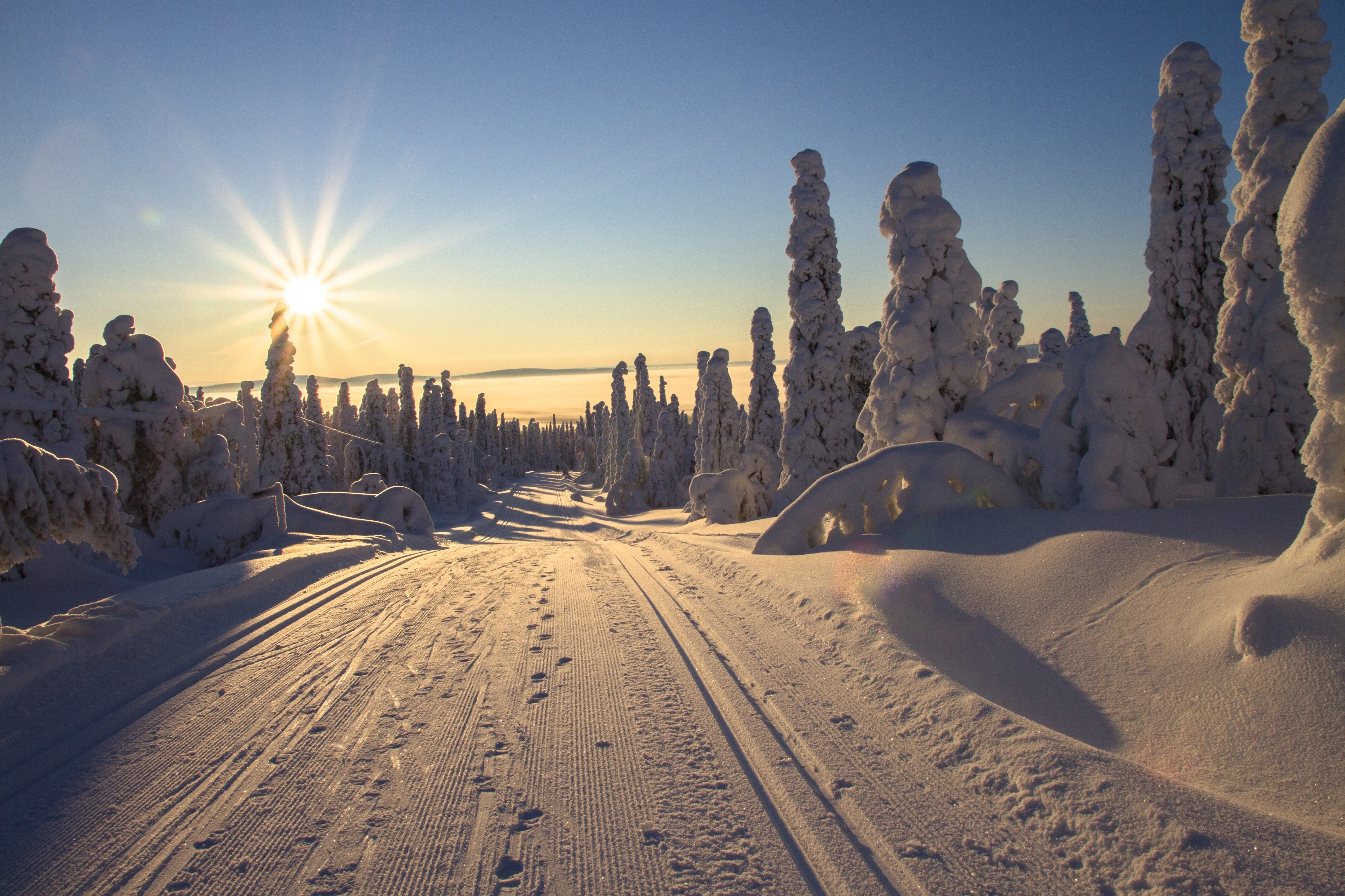 Lapin talvinen auringonnousu ja puuterilumiset hiihtomaisemat